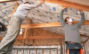 Worker insulating a garage